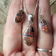 This stunning sterling silver set is created and stamped by Navajo artist Sheryl Martinez. It features an inlay design of Wild Horse, Jet & Opal. The earrings measure 1.2" long including the ear wire by 0.4" wide. The pendant measures 1.3" long (from the top of the bail) by 0.5" wide.Pictured on a 1 mm chain which is sold separately here. Southwestern Style Sterling Silver Jewelry Gift, Artisan Red Jewelry With Inlay, Red Southwestern Style Collectible Jewelry, Artisan Red Inlay Jewelry, Southwestern Sterling Silver Gemstone Jewelry, Southwestern Style Jewelry In Sterling Silver, Red Sterling Silver Jewelry With Polished Finish, Southwestern Style Jewelry In Sterling Silver Stamped 925, Southwestern Sterling Silver Jewelry Stamped 925