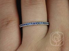 a woman's hand with a diamond and blue sapphire band on her ring finger