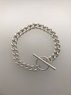 This is a beautiful heavy solid silver curb chain bracelet with a stylish toggle clasp.  Easy everyday bracelet to wear on its own or layered with others favourites. Length of bracelet approx: 19cm Width of chain approx: 8mm This item is made to order, so please allow up to 10 working days for delivery. You can view more beautiful jewellery here: LapisAndCoral.etsy.com Classic Sterling Silver Bracelet With Chunky Chain, Modern Silver Cuban Link Bracelet With Chunky Chain, Classic Sterling Silver Chunky Chain Bracelet, Modern Sterling Silver Curb Chain Bracelet, Classic Silver Cuban Link Bracelet With Chunky Chain, Modern Silver Charm Bracelet With Chunky Chain, Silver Oval Link Curb Chain Bracelet, Silver Curb Chain Bracelet With Oval Link, Sterling Silver Chunky Chain Bracelet