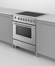 a stainless steel stove top oven in a kitchen with white counter tops and gray cabinets