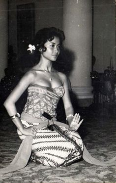 an old photo of a woman sitting on the floor