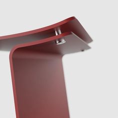 a red curved table with a light on it's side and the top half turned upside down