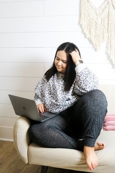 a woman sitting on a couch using a laptop computer