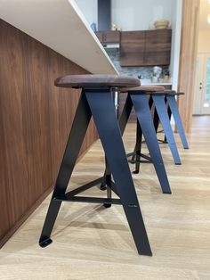 three stools are sitting in the middle of a room with wood floors and walls