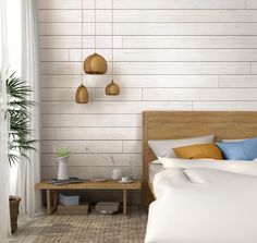 a bedroom with white brick walls and wooden furniture, including a bed that has blue pillows on it