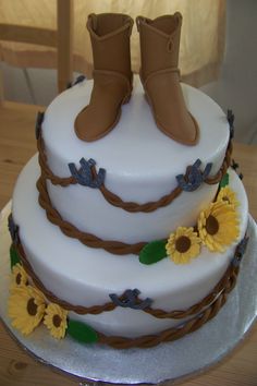 a white cake with sunflowers and boots on top