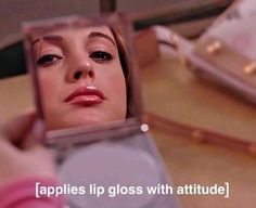 a woman is looking in the mirror with her eyes closed and there is text that reads apples lip glosss with attitude