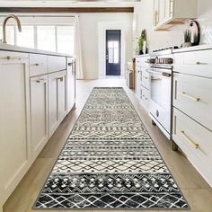 a kitchen with white cabinets and an area rug on the floor