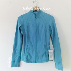 Description: Lululemon Define Jacket *Luon In Tidal Teal (Tdlt). Beautiful Teal Blue Color. Released In April 2023. Discontinued Color. Special Collector’s Item. Has An Elastic Zipper Pull (Or Hair Tie) Attached To The Front Zipper. Up For Adventure. And Ready For Downtime. Made From Cottony-Soft Luon Fabric. Zippered Pockets. Has Thumbholes & Cuffins. Slim Fit, Hip Length. Sold Out. Size: Size 6 Condition: Brand New With Tags (Nwt). Never Worn! Authentic Lululemon Purchased Directly From The Lu Light Blue Long Sleeve Athleisure Activewear, Functional Blue Outerwear For Workout, Blue Spring Outerwear For Workout, Blue Spring Workout Outerwear, Spring Workout Blue Outerwear, Fitted Functional Blue Outerwear, Blue Lululemon Jacket, Lulu Wishlist, Cute Lululemon Outfits