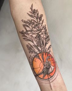 a bird and flowers tattoo on the arm