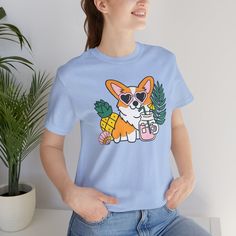 Introducing our Summer Corgi Unisex Graphic Tee – a must-have addition to your warm-weather wardrobe that combines adorable corgi charm with the laid-back vibes of summer! This tee isn't just clothing; it's a fun and stylish way to celebrate your love for these delightful pups and the sunny season. Crafted for both men and women who adore corgis, this tee is perfect for adding a touch of whimsy to your summer look, whether you're lounging at the beach or soaking up the sun by the pool. Featuring a playful corgi graphic and made from high-quality materials for comfort and durability, this tee is sure to become a favorite in your collection. Whether you're a proud corgi lover or searching for the perfect gift for a fellow dog enthusiast, our Summer Corgi Unisex Graphic Tee is guaranteed to b Dog Print Crew Neck Graphic Tee, Summer Dog Print Relaxed Fit T-shirt, Summer Relaxed Fit T-shirt With Dog Print, Trendy Crew Neck T-shirt With Dog Print, Relaxed Fit Short Sleeve Tops With Dog Print, Cotton Crew Neck Top With Dog Print, Summer Dog Print Graphic Tee, Summer Dog Print Short Sleeve Top, Summer Short Sleeve T-shirt With Dog Print