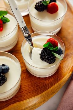 small desserts with berries and cream on a wooden tray