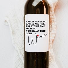 a bottle of wine that has some writing on the label and is next to a white blanket