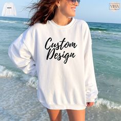 Revamp your wardrobe with our personalized sweatshirt collection, featuring comfortable oversized styles and custom designs. Whether it's a unique gift for the woman in your life or a custom logo sweatshirt, our selection offers something for everyone.  Made with a medium-heavy fabric blend of 50% cotton and 50% polyester, this sweatshirt feels cozy and is the perfect choice for those colder months. The classic fit along with the crew neckline deliver a comfy wearing experience with a clean-cut style. A crewneck sweatshirt is pure comfort. These garments are made from polyester and cotton. This combination helps designs come out looking fresh and beautiful. The collar is ribbed knit, so it retains its shape even after washing. There are no itchy side seams on these sweaters.  Meanwhile, th Customizable Casual Crew T-shirt, Oversized White Sweatshirt With Custom Print, White Cotton Sweatshirt With Custom Print, Customizable White Crew T-shirt, Customizable Oversized Crew Neck T-shirt, Casual Sweatshirt With Custom Print And Crew Neck, Casual Crew Sweatshirt With Custom Print, Custom Text Long Sleeve Tops For Streetwear, White Crew Neck Hoodie With Custom Print