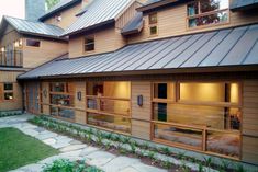 a large wooden building with lots of windows on it's sides and a metal roof