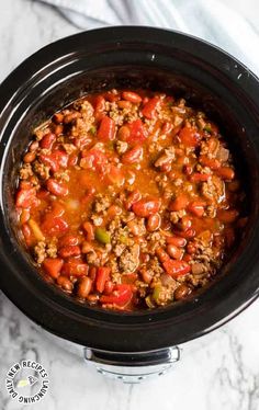 a crock pot filled with chili and meat in it on top of a marble counter