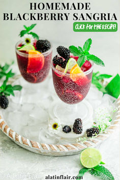 homemade blackberry sangria with lime and blackberries in glasses on a white platter