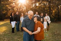 a group of people standing on top of a grass covered field next to each other