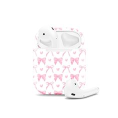 an apple airpods case with pink bows and hearts on it, sitting next to a pair of headphones