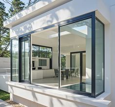 a modern house with glass walls and sliding doors