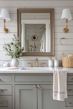 a bathroom vanity with two sinks and a mirror above it, along with gold faucets