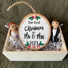 a personalized christmas ornament in a wooden box with two figurines