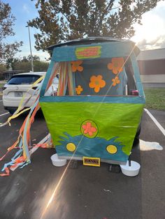 an ice cream cart parked in a parking lot with balloons and streamers around it