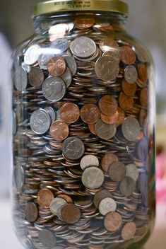 a jar full of coins with a quote on the top that says, finance and prosperity