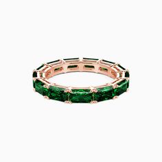 an emerald colored ring set in 18k rose gold, with baguettes on each side