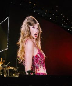 a woman with long hair is performing on stage