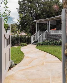 an open door leading to a house with a stone walkway in the front yard and stairs on either side