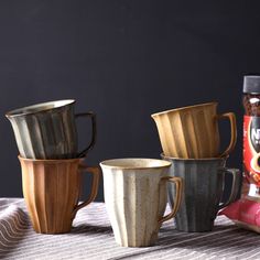 four coffee mugs sitting on top of a table next to a bag of nutella