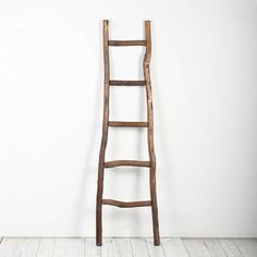 an old wooden ladder leaning against a white wall