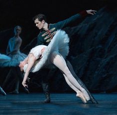 two ballerinas are performing on stage with one holding the other