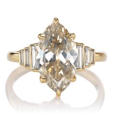 an oval cut diamond ring with three baguets in yellow gold and white diamonds