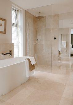 a large white bath tub sitting next to a walk in shower