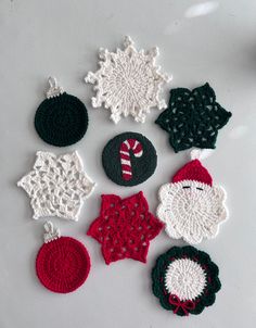 crocheted christmas ornaments are displayed on a white surface with red and green accents