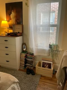 a bedroom with a bed, dresser and bookshelf in front of a window