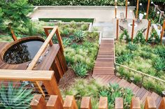 an aerial view of a garden with wooden steps leading up to the pool and deck area