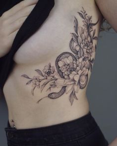 a woman with a snake and flowers tattoo on her stomach