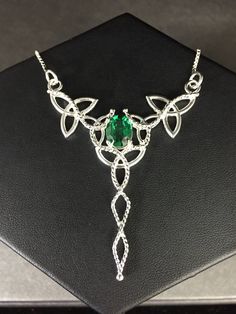 "I've designed this long, statement Celtic inspired necklace entirely in sterling silver featuring a center, faceted 10x8mm peridot gemstone! The frame, or centering, of the pendant is made with Celtic Trinity Knots and sterling wire work braids down the center to add the balancing touches to the piece. It comes with a sterling box chain which is soldered to each end of the pendant. This piece is 18\" in length, including the chain, and the pendant, itself, is approximately 3 inches, in height, Silver Sterling Silver Hallmarked Emerald Necklace, Silver Peridot Jewelry For Anniversary, Hallmarked Silver Sterling Silver Emerald Necklace, Hallmarked Sterling Silver Emerald Necklace, Silver Sterling Silver Emerald Necklace For Anniversary, Silver Emerald Necklace In Sterling Silver, Formal Peridot Jewelry For May Birthstone, Sterling Silver Emerald Pendant Necklace For Wedding, Sterling Silver Emerald Necklace For Weddings In May