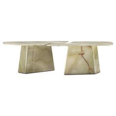 two white marble tables sitting on top of each other