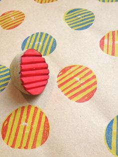 a red object sitting on top of a piece of paper with colorful circles around it