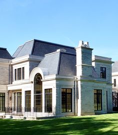 a large white house sitting on top of a lush green field