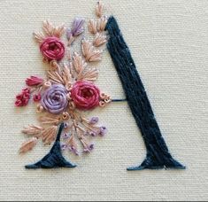 an embroidered letter with flowers on it