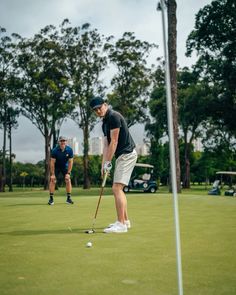 two men are playing golf on the green