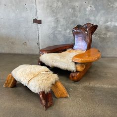 two wooden chairs with sheep skin on them