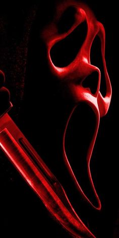 a pair of scissors with red light shining on it's blades in the dark