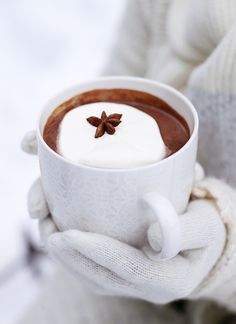 there is a cup of hot chocolate in someone's hand with a star on top