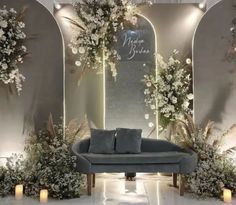 a couch sitting in front of a wall with flowers and greenery on the walls